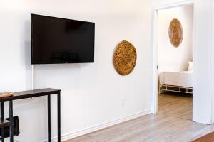 a living room with a flat screen tv on a wall at AFRICA - SelfCheckIn - Plateau - St-Laurent in Montréal