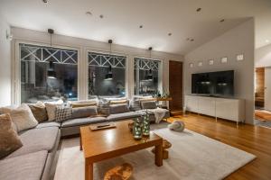 una sala de estar con un sofá y una mesa en Arctic Circle Luxury House - close to Santa's Village, en Rovaniemi