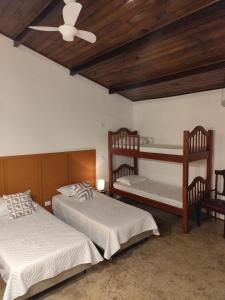 a bedroom with two bunk beds and a ceiling fan at Chalés Com Quadra de Areia in São Sebastião