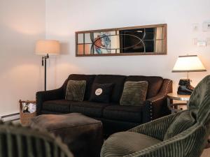 una sala de estar con un sofá y dos sillas en Mountain Escape Ski-In Ski-Out Laurentians, en Saint-Faustin