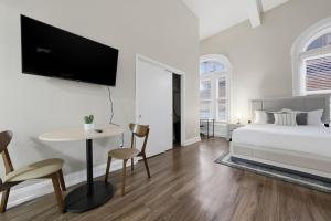 a white bedroom with a bed and a table and chairs at Relaxing studio perfect for extended visits in New Haven