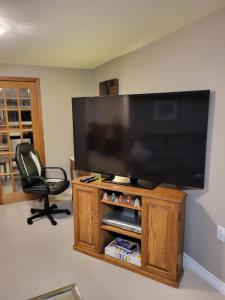 a living room with a large flat screen tv at Cozy Suite with HOT TUB & Highspeed Internet in Grimsby