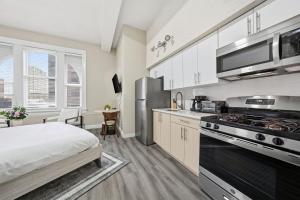 a kitchen with a bed and a stove top oven at Homey studio perfect for long-term guests in New Haven