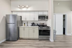 a kitchen with white cabinets and a stove and refrigerator at Homey studio perfect for long-term guests in New Haven +16 photos