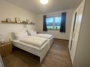 En eller flere senge i et værelse på Ferienhäuser Wintermoor