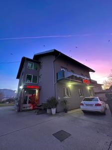 a white car parked in front of a building at Hostel Herz in Banja Luka