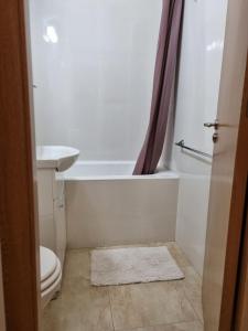 a bathroom with a toilet and a tub and a sink at Iza Suite in Craiova +11 photos