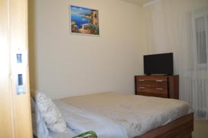 a bedroom with a bed and a tv on a dresser at Iza Suite in Craiova