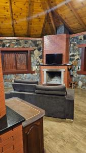 a living room with a couch and a stone fireplace at SIG - Rancho Desiam - Serra Gaúcha in Gramado