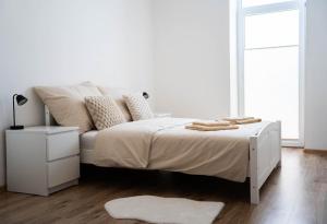 Un dormitorio blanco con una cama blanca y una ventana. en Tatry view apartment, en Suchá Hora