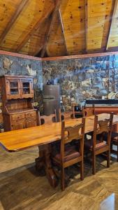 a large wooden table in a room with a stone wall at SIG - Rancho Desiam - Serra Gaúcha in Gramado