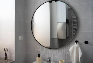 un baño con espejo y lavabo en Tatry view apartment, en Suchá Hora 27 fotos más