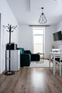 Una sala de estar con un sofá verde y una mesa. en Tatry view apartment, en Suchá Hora