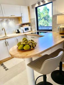 eine Küche mit einem Tisch mit einer Obstschale darauf in der Unterkunft Ali'i Tahiti in Papeete