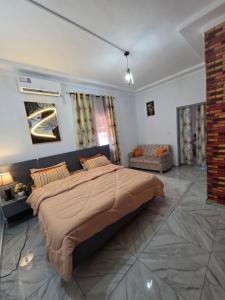 圣佩德罗Résidence Éden San pedro的带一张大床和一张沙发的卧室