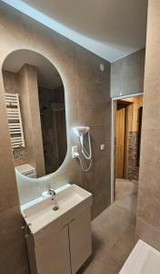 a bathroom with a sink and a mirror at Apartament z widokiem na panoramę Tatr "AppWidokowa9" in Gliczarów Górny