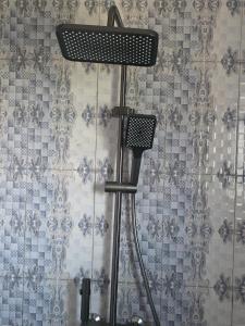 a shower head in a bathroom with a wall at Résidence Éden San pedro in San-Pédro