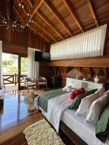 Un dormitorio con una cama grande y un techo de madera. en Morada Das Grimpas, en Palmeira