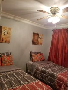 une chambre avec deux lits et un ventilateur de plafond dans l'établissement Home away from Home Comfort, à Savannah