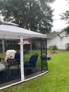 - un kiosque avec des chaises et une table dans la cour dans l'établissement Home away from Home Comfort, à Savannah