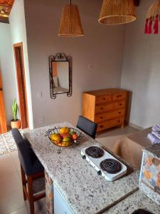 a kitchen with a bowl of fruit on a counter at Loft de Cristal Igatu in Andaraí +2 photos