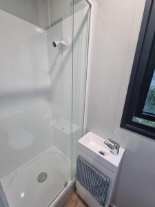 Un baño blanco con ducha y lavabo. en Gore Bay View, en Gore Bay