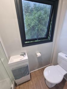 Un baño con inodoro y ventana. en Gore Bay View, en Gore Bay