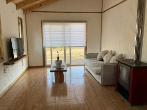 a living room with a couch and a television at CABAÑAS BRISAS VOLCANICAS in Cunco