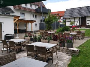 an outdoor patio with tables and chairs and flowers at Gasthaus Adler in Calw