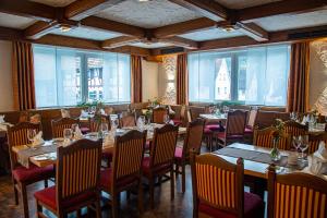 a dining room with tables and chairs and windows at Gasthaus Adler in Calw