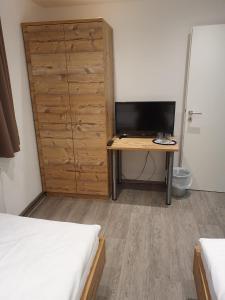 - une chambre avec un bureau, une télévision et une armoire dans l'établissement Gasthaus Adler, à Stammheim