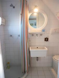 Un baño blanco con lavabo y espejo. en Casa di Bimba, en Quarto