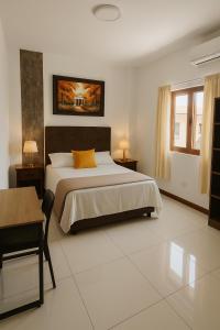 Un dormitorio con una cama grande y una mesa. en Deluxe Hotel Talara! cerca aeropuerto, plaza vea, plaza de armas, centros de negocios y turismo, en Talara