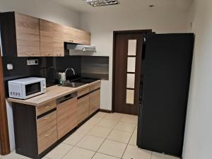 a kitchen with a black refrigerator and a microwave at Noclegi w mieście in Kozienice