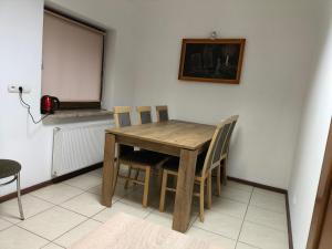 a wooden table and chairs in a room at Noclegi w mieście in Kozienice +3 photos