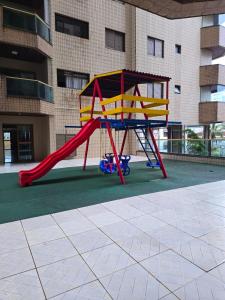 a playground with a slide in front of a building at Apto 2 quartos com Piscina e Vista Mar Oportunidade Única in Mongaguá