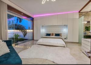 Luxury house, heated pool and Turkish bath Laurels! في ميديلين: غرفة نوم بسرير كبير مع اضاءة ارجوانية