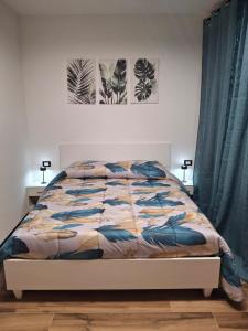 Un dormitorio con una cama y dos cuadros en la pared. en RELAIS SUITE Modena Parc, en Módena