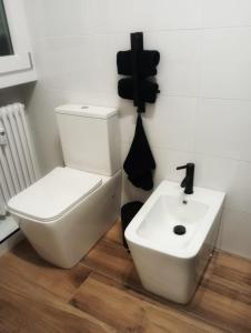 Un baño con un inodoro blanco y un lavabo. en RELAIS SUITE Modena Parc, en Módena