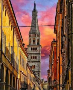 un edificio alto con un campanario en una calle de la ciudad en RELAIS SUITE Modena Parc, en Módena