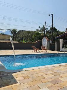 a swimming pool with a water fountain at Chalés Com Quadra de Areia in São Sebastião +22 photos