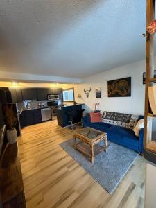 a living room with a blue couch and a table at Cozy boho downtown apartment in Calgary