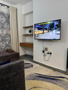 a living room with a flat screen tv on a wall at BonBon Residency in Kiambu