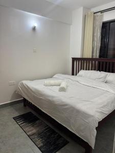 a bedroom with a large bed with white sheets at BonBon Residency in Kiambu