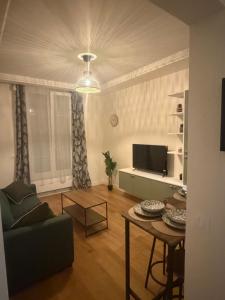 een woonkamer met een bank en een tafel bij Cosy Hoche Saint Gervais in Pré Saint Gervais