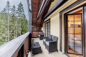 a balcony of a house with chairs and a table at Apartmán Helena 15 a Helena 21 Hrabovo in Ružomberok