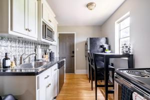 a kitchen with a sink and a refrigerator at Jungle House Luxury Stays - Columbus Downtown Short North in Columbus