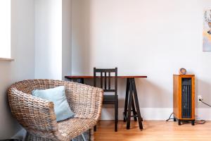 a wicker chair with a blue pillow sitting next to a table at Jungle House Luxury Stays - Columbus Downtown Short North in Columbus +33 photos