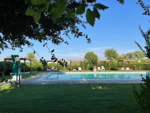 a large swimming pool in a park with green grass at Agriturismo Il Querciolo in Grosseto