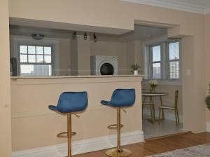 a kitchen with two blue chairs and a bar at The Cozy Luxe Retreat, Central West End in Saint Louis